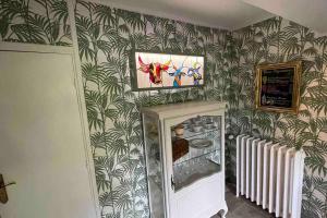 - une cuisine avec réfrigérateur dans une chambre avec papier peint dans l'établissement Gîte de charme Autun'Home, à Autun