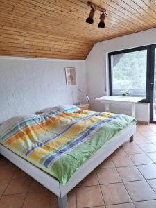 a bed in a bedroom with a wooden ceiling at Eifelliebe Monschau in Monschau