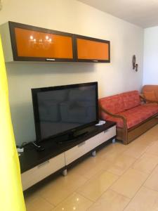 uma sala de estar com uma televisão de ecrã plano e um sofá em Lili's House Golem, Durres em Golem