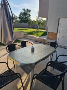 einen Tisch mit 2 Stühlen und einem Sonnenschirm in der Unterkunft Apartman Lena in Zadar