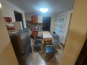 a kitchen with a table and chairs and a refrigerator at Casa de vacanta in Tara Fagarasului in Beclean