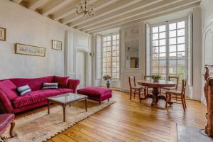 Demeure Jousset des Berries في لو مان: غرفة معيشة مع أريكة حمراء وطاولة
