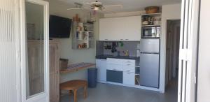 eine Küche mit weißen Schränken und einem Kühlschrank in der Unterkunft Grau du Roi - Rive droite - Plage du Boucanet in Le Grau-du-Roi