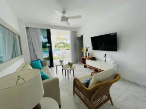 a living room with a couch and a tv at rock star B101 in Punta Cana