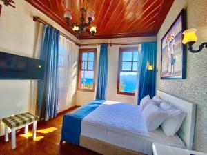 um quarto com uma cama grande e cortinas azuis em Ulivo Hotel em Antalya