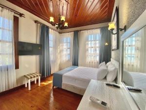um quarto com uma cama e algumas janelas em Ulivo Hotel em Antalya