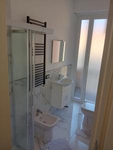 een witte badkamer met een wastafel en een toilet bij elios home in Genua