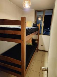 two bunk beds in a room with a window at Cómodo departamento diario. in Iquique
