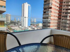 a table on a balcony with a view of a city at Cómodo departamento diario. in Iquique