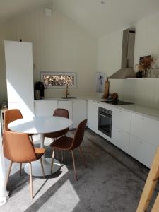 a kitchen with a table and chairs in a room at The Black and White cabin with Spa bath in Västra Torup