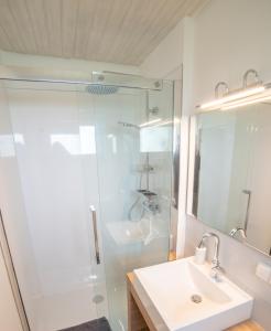 uma casa de banho branca com um lavatório e um chuveiro em Ferienhaus Rhön-Auszeit em Bischofsheim an der Rhön