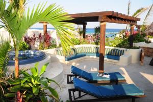 a patio with two blue chairs and a table at El Taj Oceanfront and Beachside Condo Hotel in Playa del Carmen