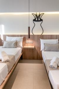 a bedroom with two beds and a vase on the wall at Pantheon Sea View in Nei Poroi