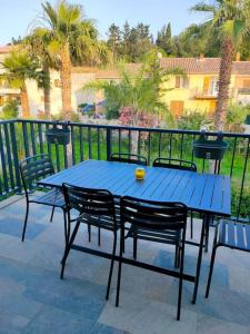 uma mesa azul e cadeiras num pátio em Appartement neuf avec balcon et 2 chambres em Saint-Florent