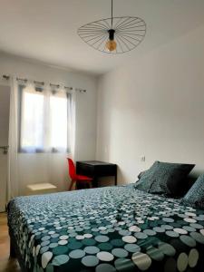 a bedroom with a bed with a black and white comforter at Appartement neuf avec balcon et 2 chambres in Saint-Florent