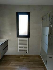 uma casa de banho com uma janela, um lavatório e um chuveiro em Appartement neuf avec balcon et 2 chambres em Saint-Florent