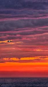 a plane flying in the sky over the ocean at Batumi Palm Hotel in Batumi