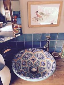 a sink in a bathroom with a picture on the wall at Luxurious 1930s Showman's Wagon in Heathfield +12 photos