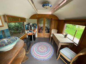 a living room with a table and a wooden table sidx sidx sidx at Luxurious 1930s Showman's Wagon in Heathfield