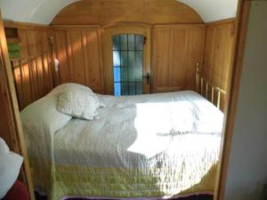 a bedroom with a large bed with a window at Luxurious 1930s Showman's Wagon in Heathfield