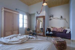 ein Schlafzimmer mit einem Bett, einem Sofa und einem Spiegel in der Unterkunft Amymone and Adiandi in Nafplio