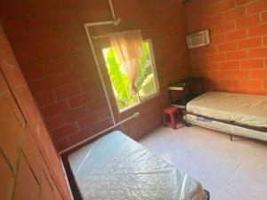 Habitación pequeña con cama y ventana en Villa Celeste, en Arboletes