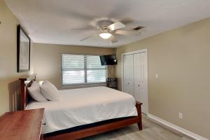 - une chambre avec un lit et un ventilateur de plafond dans l'établissement The Yellow House, à Gulf Breeze