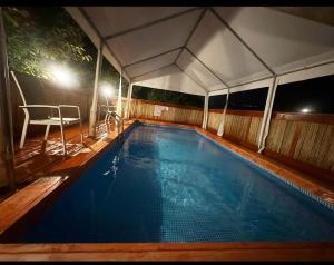 una piscina bajo una marquesina por la noche en פינה במעיין en Mishmār Hāyardin