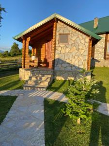 una cabaña con una pasarela de piedra delante de ella en Ethno House Bektesevic en Gusinje