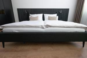 ein Bett mit weißer Bettwäsche und Kissen darauf in der Unterkunft E D E L H O F . R O O M in Jois