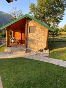 um pequeno edifício de pedra com um telhado verde em Ethno House Bektesevic em Gusinje