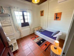 een kleine kamer met een bed en een raam bij Bungalow Gaspardo , 2 chambres climatisées , à 2 mins à pied de la plage , wifi , jardin clos, parking ,sans vis-à-vis au Carbet in Le Carbet