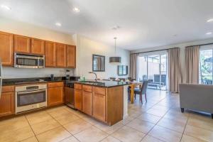 a kitchen with wooden cabinets and a table with a sink at TVPM-2678TWithRO townhouse in Orlando