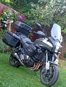 a motorcycle parked in the grass in a yard at Apartments Vratnik in Sarajevo