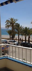 balcón con vistas a la playa y a las palmeras en TAO 1 Primera línea de Playa VELILLA, en Almuñécar