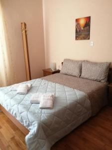 1 dormitorio con 1 cama grande y toallas. en Aunt Vaso Sweet Home, en Ptolemaida