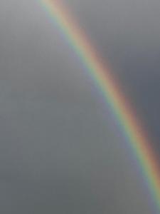 un arc-en-ciel dans le ciel avec un ciel nuageux dans l'établissement Chambre proche Elysée, à Paris