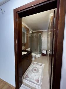y baño con ducha, lavabo y aseo. en شقة كبيرة Trapzon Merkezi عالبحر en Soğuksu