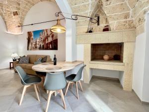 een woonkamer met een tafel en een open haard bij Suite La Basilica in Galatina