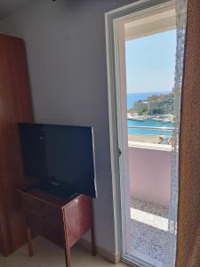a room with a television and a door to a window at Apartments Djakonovic in Ulcinj