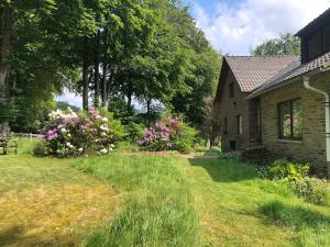 a house with a yard with grass and flowers at Le refuge de Kila in Waimes