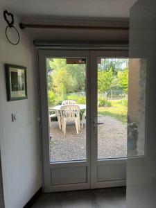 una puerta que conduce a un patio con una mesa en Le refuge, en Ceton
