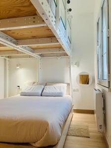 a bedroom with a white bed with a ladder at Apartamento Maribel a pie de pista in Sierra Nevada