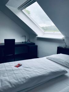 a bedroom with a bed and a window at Landhotel Zerlaut in Kißlegg