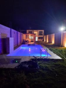 una piscina notturna con un edificio e luci di Casa de Campo Las Tujas a Lunahuaná