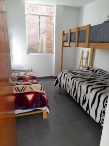 1 dormitorio con 2 camas y ventana en Casa de Campo Las Tujas, en Lunahuaná