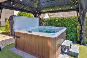 una bañera de hidromasaje bajo una sombrilla en un patio en River Waterfront Paradise Vacation Home, en Terrebonne