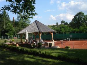 a gazebo on a tennis court with a tennis court at Chateau Radvanov Pension in Mladá Vožice