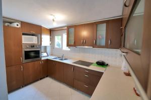 a kitchen with wooden cabinets and a sink and a microwave at Gurra room's in Lukovë