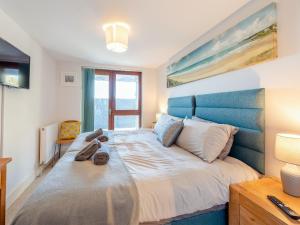 1 dormitorio con 1 cama grande y cabecero azul en Beachbreak - Uk42996, en Woolacombe